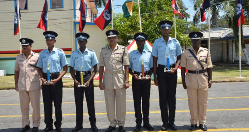 Top performers  from recent police training courses (with trophies)  pose with Police Commissioner Seelall Persaud (centre) , Assistant Commissioner David Ramnarine (left) and Senior Superintendent Paul Williams, Force Training Officer (right).