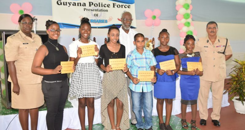 Senior Police Superintendent Maxine Graham (left); Senior Technical Advisor of the MoE, Mr. Vincent Alexander; and Acting Commissioner of Police, Mr. David Ramnarine, pose with the top awardees