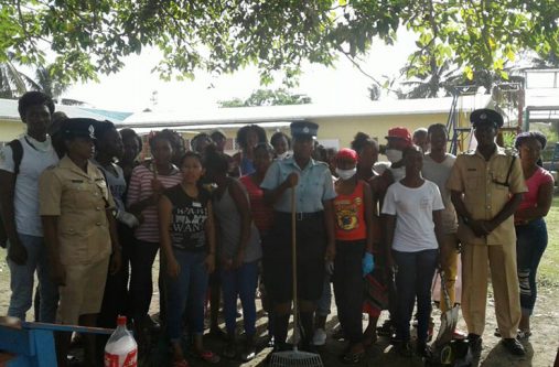Police ranks with members of Youth Biz 592 before the start of the clean-up exercise