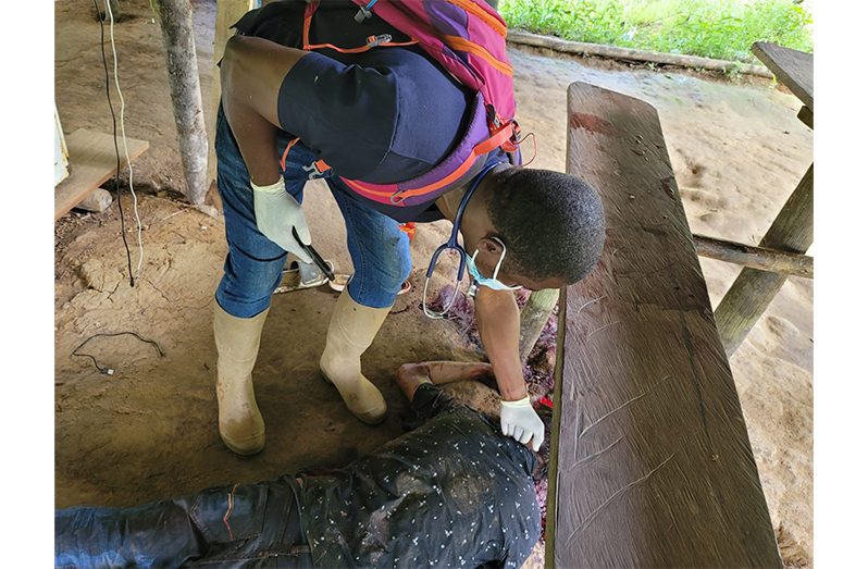 A police rank examining Raynold John’s body. (GPF photo)