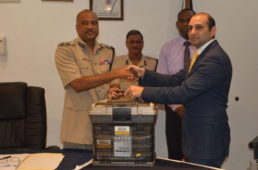 Police-receive Dr. Maurice Aboud handing over the forensic kit to Commissioner of Police, Seelall Persaud.