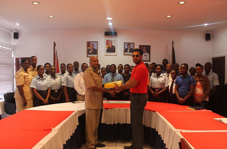 Company Director, Vickash Panday, hands over some of the items to Commissioner Seelall Persaud at his Eve Leary Conference Room, in the presence of the ranks.