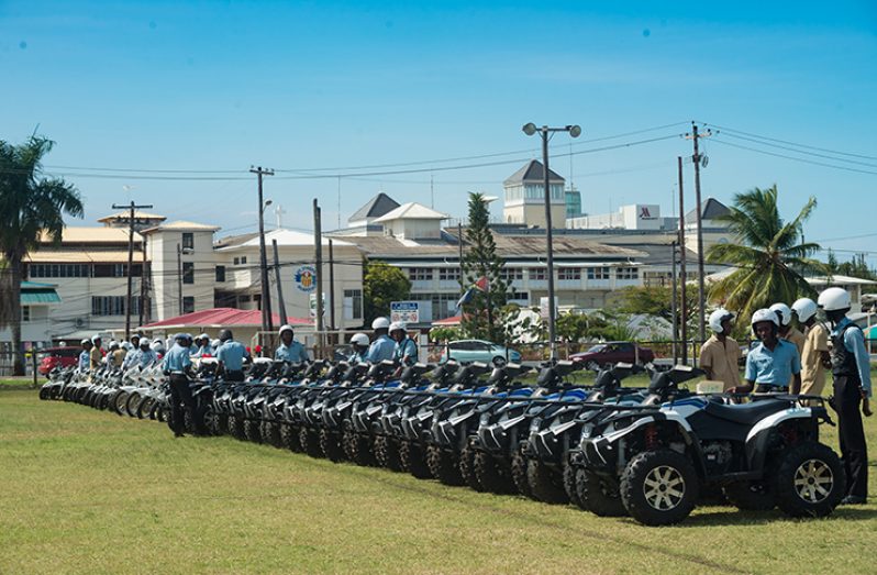 ATVs and motorcycles being inspected by ranks of the Guyana Police Force