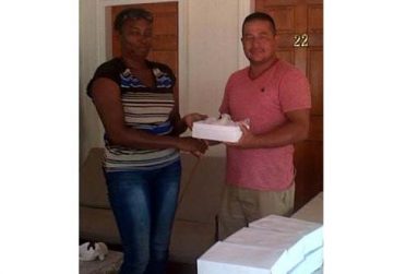 Secretary of Pomeroon Sports Committee, Verna D’Aguiar, hands over a box of balls to captain of Eagles Sports Club, Kenneth De Agrella.