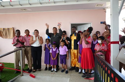 Terry Mohammed (centre) and Minister of Education, Priya Manickchand (left) with children and others at the commissioning of the Edward Mohammed Swimming Pool