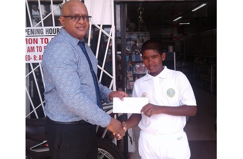 Poonai Pharmacy CEO Poonai Bhirooj hands over sponsorship to RHTY&SC Under-13 captain Matthew Pottaya.