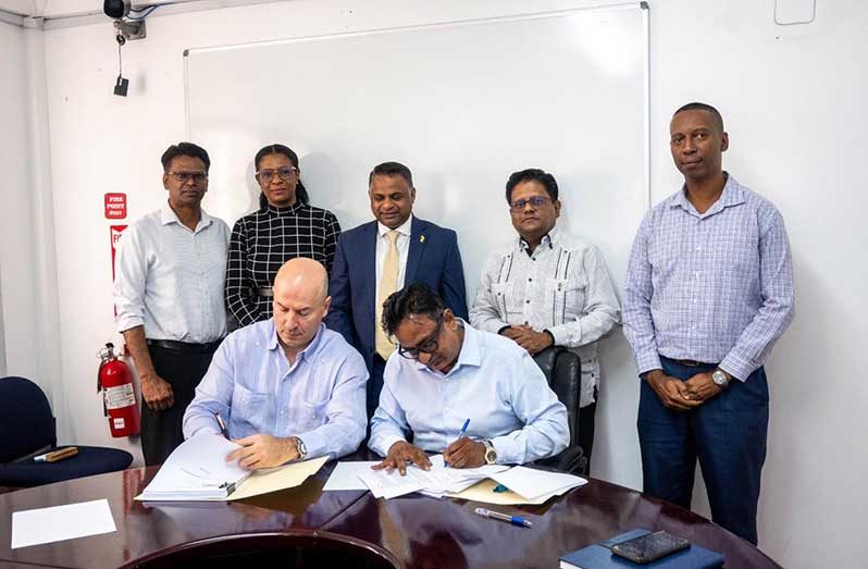 Senior Minister in the Office of the President with Responsibility for Finance and the Public Service, Dr. Ashni Singh, and Minister within the Ministry of Public Works, Mr. Deodat Indar along with other officials overlook the signing of the agreement by GPL’s Executive Management Committee Head, Mr. Kesh Nandlall and Managing Director of the Americas, UCC Holdings, Mr. Antonio Neto