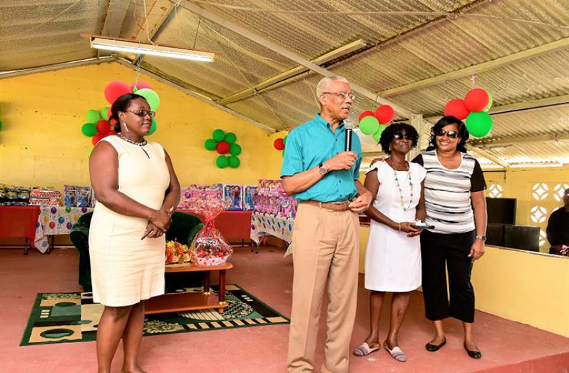 President David Granger addressing the children of West Coast Berbice. He is flanked by Minister within the Ministry of Natural Resources, Ms. Simona Broomes (left), Parliamentarian, Ms. Jennifer Wade and Minister within the Ministry of Public Infrastructure, Ms. Annette Ferguson (at extreme right)