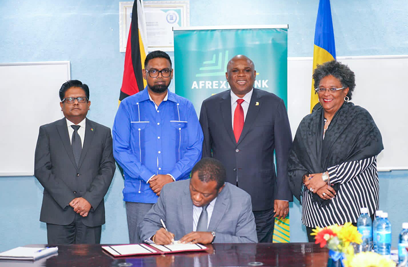 (From left) Senior Minister for finance, Dr Ashni Singh; President, Dr Irfaan Ali; President of the Afreximbank, Professor Benedict Oramah; and Barbados Prime Minister Mia Mottley stand as Foreign Affairs and International Cooperation Minister Hugh Todd signs the agreement (Office of the President photo)