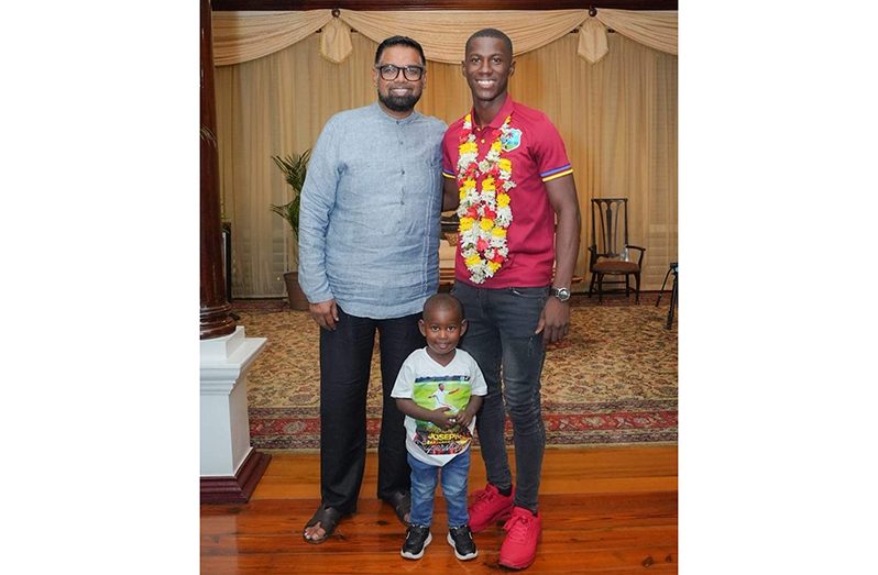 President Dr. Mohamed Irfaan Ali (left) stands with Shamar Joseph (right) and Joseph’s son
