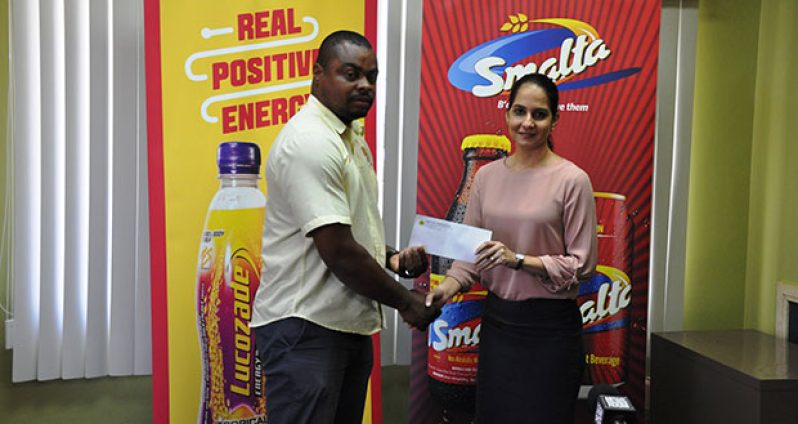 Edison Jefford (left) receives the sponsorship cheque from Ansa McAl’s Non-Alcoholic Brand Manager Anjeta Hinds yesterday.