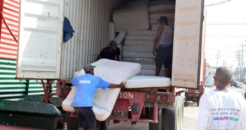 Prisoners offload 400 new mattresses donated by Food For The Poor. (Adrian Narine photo)