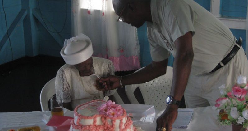 Officer-in-Charge of the N/A Prisons, Linden Cornette, shares the cake with centenarian Cecelia E. Ramsay-King (Prison photo)
