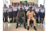 Acting Deputy Director of Prisons Kevin Pilgrim (seated left) with Officer-in-Charge of Mazaruni Prison Carlton Cameron flanked by the new prison warders