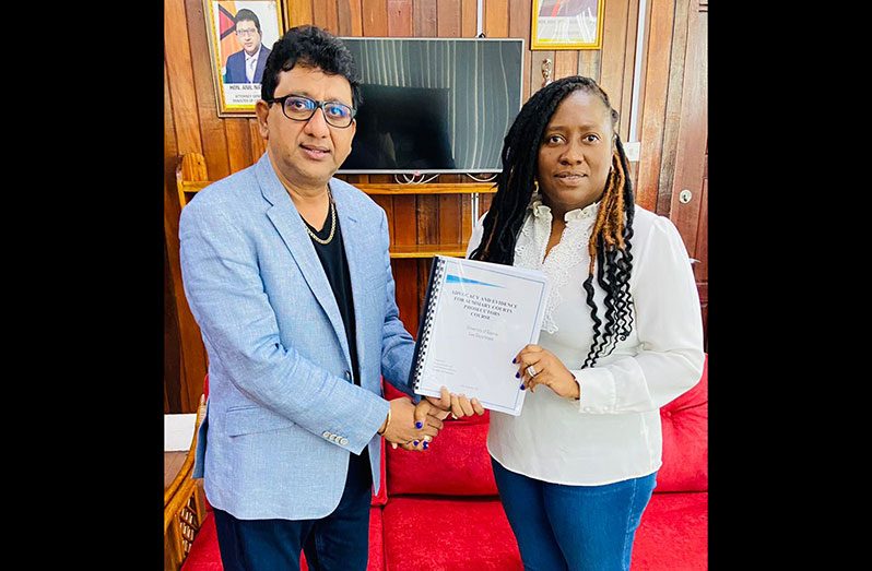 Attorney General and Minister of Legal Affairs, Anil Nandlall, S.C., handing over the ‘Advocacy and Evidence for Summary Courts Prosecutors’ Course syllabus and lecture manual to Head of the Law Department at UG, attorney-at-law, Kim Kyte-Thomas