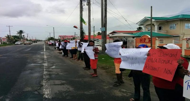 Protestors line the Crane Public road outside GECOM’s office in Region 3