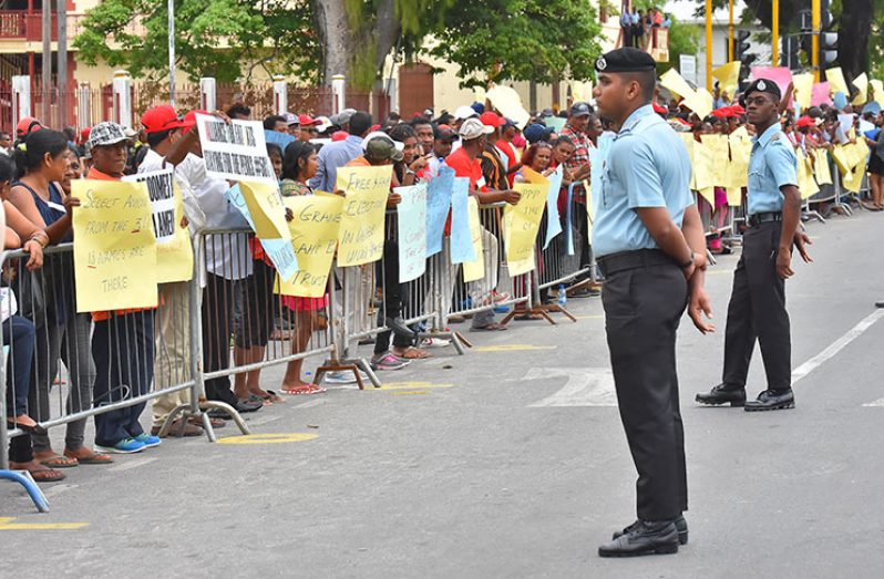 Officers look on as the protestors express their message behind the barriers (Samuel Maughn photo)