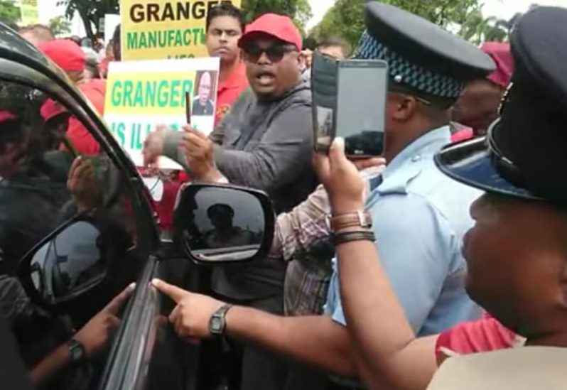 PPP Presidential candidate Irfaan Ali (in red hat) among a group of protesters outside the Pegasus Hotel on Thursday.