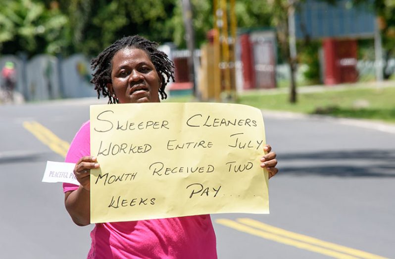 One of the protestors carrying a placard which explains one of the “injustices” meted out to sweeper/cleaners