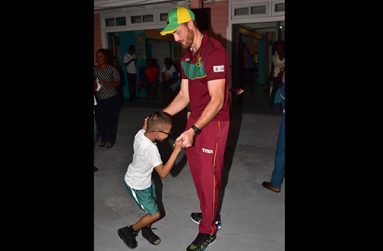 Warriors Captain Martin Guptill dances with one of the students of the Ptolemy Reid Rehabilitation centre
