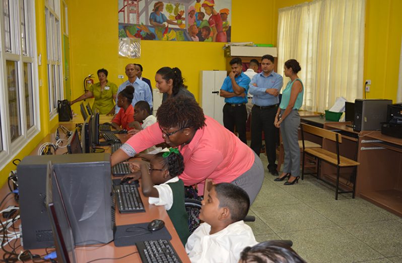Ptolemy Reid Rehabilitation Centre teachers and students test their new computer lab while a STARR Computer representative (extreme right) looks on