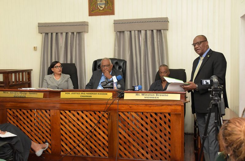 Minister of State Joseph Harmon delivers his remarks as members of the Public Service Appellate Tribunal, (seated from left to right), Ms. Abiola Wong-Inniss, retired Justice Nandram Kissoon and Mr. Winston Browne pay keen attention.