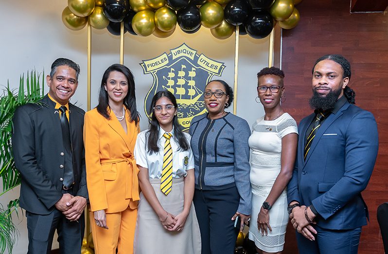 QC-OSA President (second from left) Pauline Chase, surrounded by other members of the College’s Old Students’ Association, and a current student of the school (Delano Williams photo)