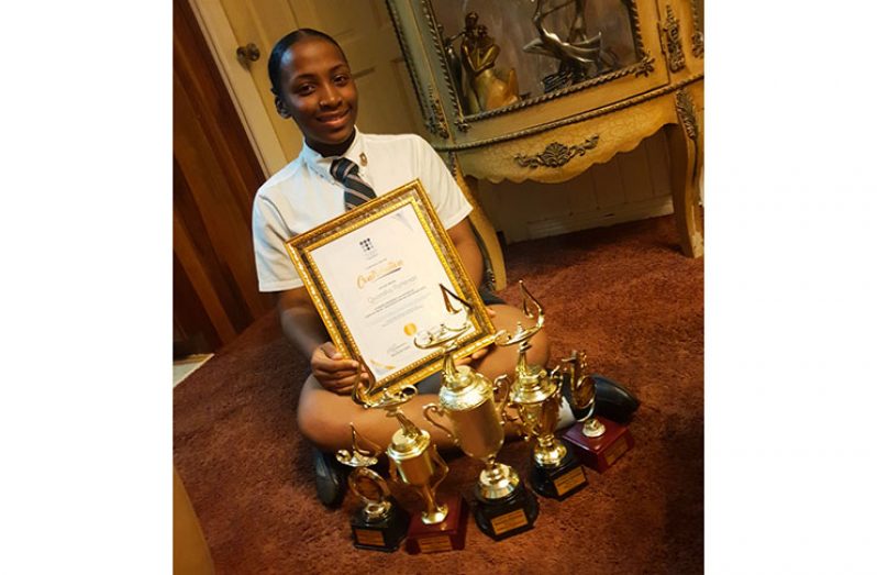 Quanisha Patterson poses with various trophies and her honorary certificate from The League of Poets (Photo courtesy of Quanisha Patterson)