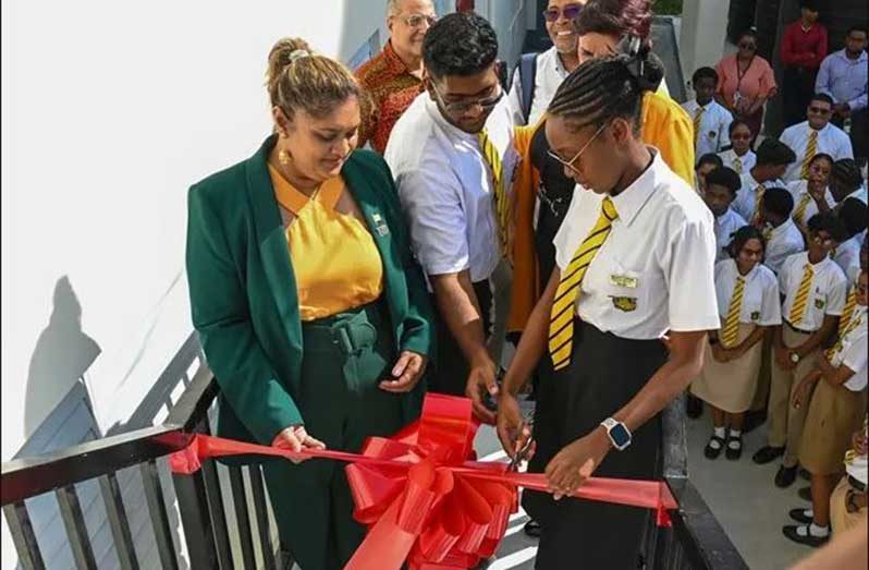 Minister of Education Priya Manickchand and students of Queen’s College cut the ribbon to commission the refurbished Industrial Technology and Home Economics Department