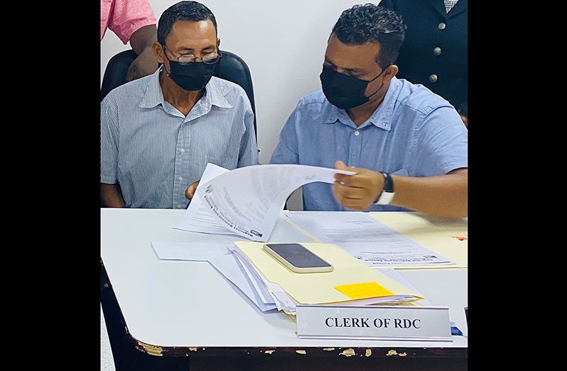 Toshao of Wakapoa, Llyod Perreira, and Regional Executive Officer, Devanand Ramdatt, sign the contract for the construction of the bridge