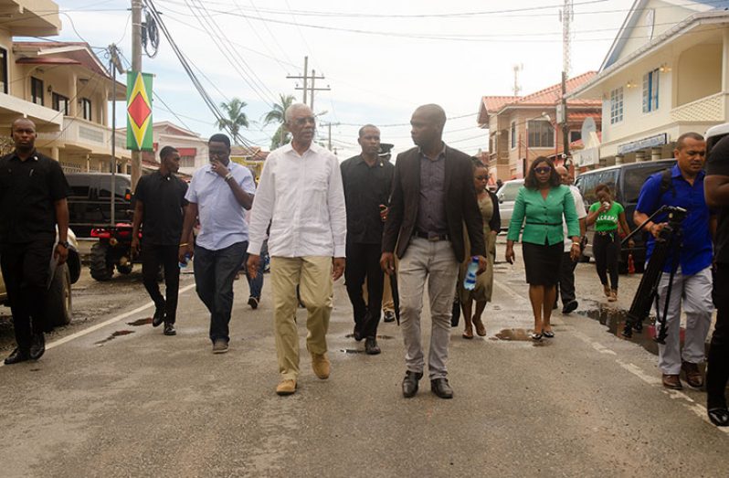 President David Granger being escorted by Mayor of Bartica, Gifford Marshall, during a walkabout in the township on Tuesday (Delano Williams photo)