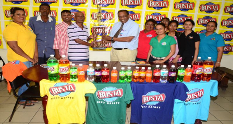 Members of the Rose Hall Town Youth and Sports Club collect their Busta Champion of Champions trophy from General Manager Robert Selman. (Adrian Narine photo)
