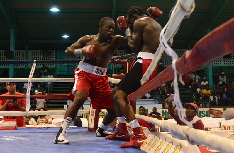 Guyana’s Derick Richmond (left) on the attack against Barbados’ Keithland King during the second round of their middleweight contest at the CASH on Saturday night. King went on to win the fight by a TKO