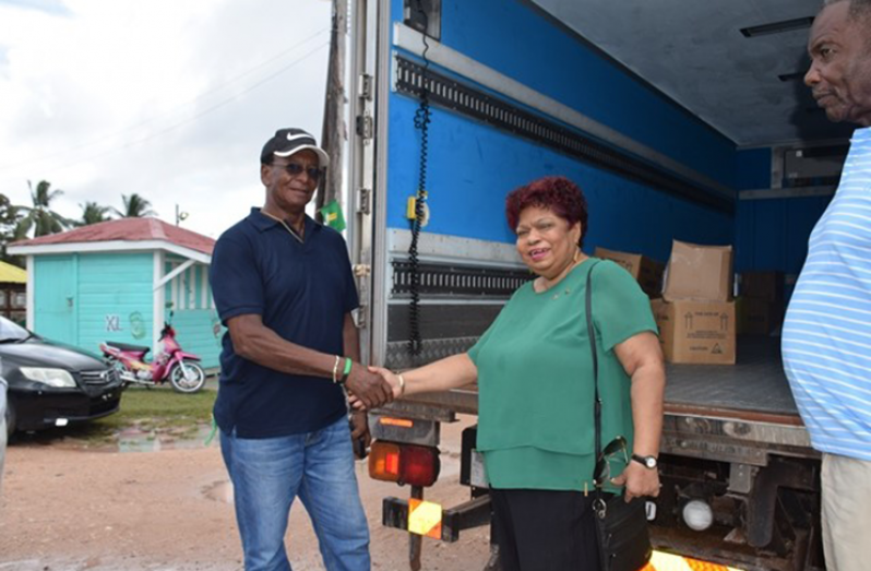 Minister of Social Protection,  Amna Ally, hands over food hampers to the laid off RUSAL workers