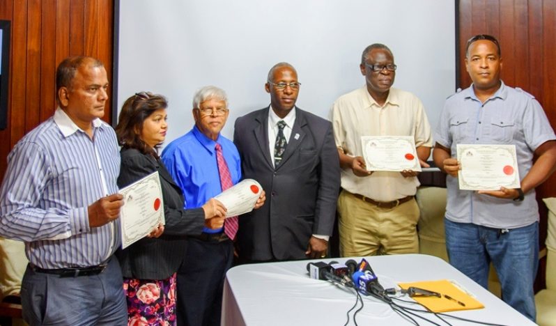 GNBA Chairman , Leslie Sobers (center) stands alongside the new radio licensees.