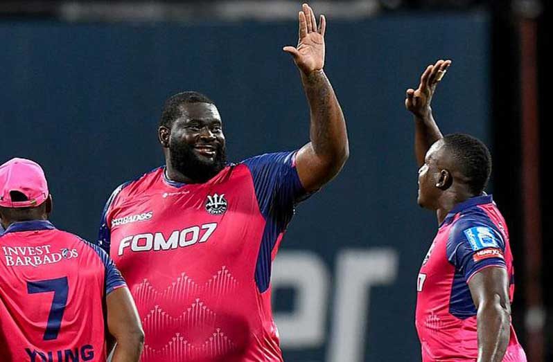 Rahkeem Cornwall (centre) celebrates with captain Rovman Powell after capturing one of his five wickets against the Patriots