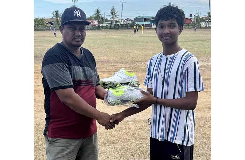 Rajbance Hemra, left, hands over the cricket shoes to Altaf Ali.