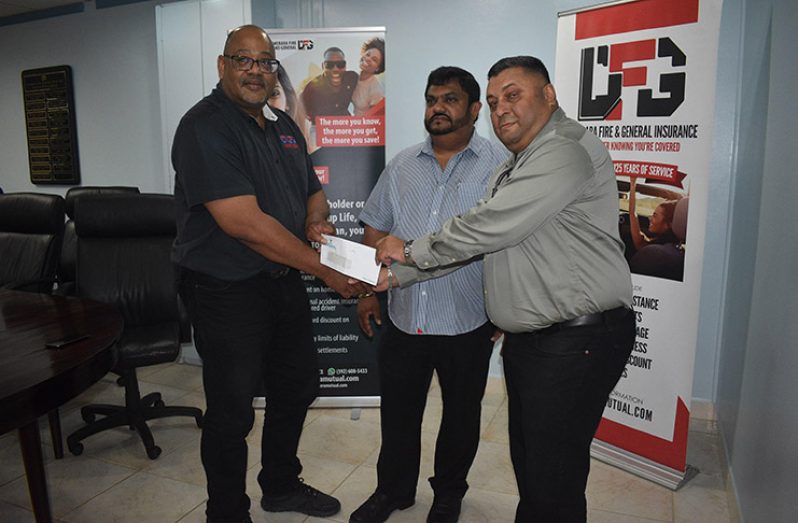  Executive Marketing Manager of Dem Life Clarence Perry (left) makes the presentation to Rajendra Singh (right) while Dave Narine looks on (John Ramsingh photo)