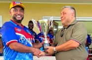 Former Guyana and West Indies Test opener Ryan Ramdass receives the Championship Trophy from Raj Singh.