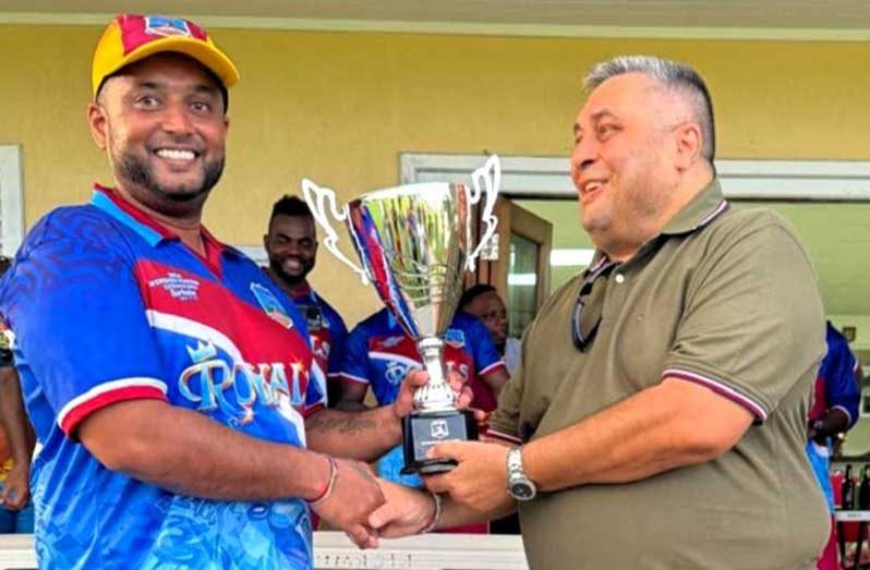 Former Guyana and West Indies Test opener Ryan Ramdass receives the Championship Trophy from Raj Singh.