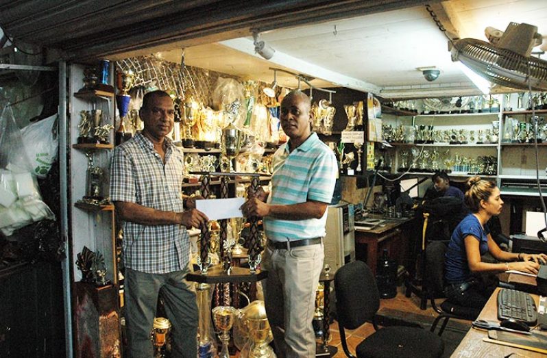 Managing Director of Trophy Stall, Ramesh Sunich, presents the cheque and first place trophy to Three Peat Promotions’ Rawle Welch yesterday
