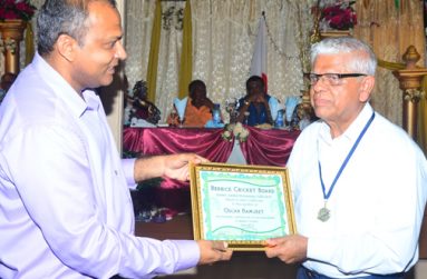 Florida-based Guyanese Oscar Ramjeet (right) accepts his Tribute to Heroes Certificate from Minister of Sport Dr Frank Anthony, during the hosting of the BCB’s Diamond Jubilee Anniversary Dinner last Sunday night. (Photo by Adrian Narine)