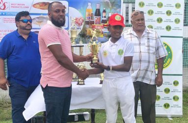 Coach Julian Moore presents Berbice opener Rampertab Ramnauth with the Best Batsman trophy.