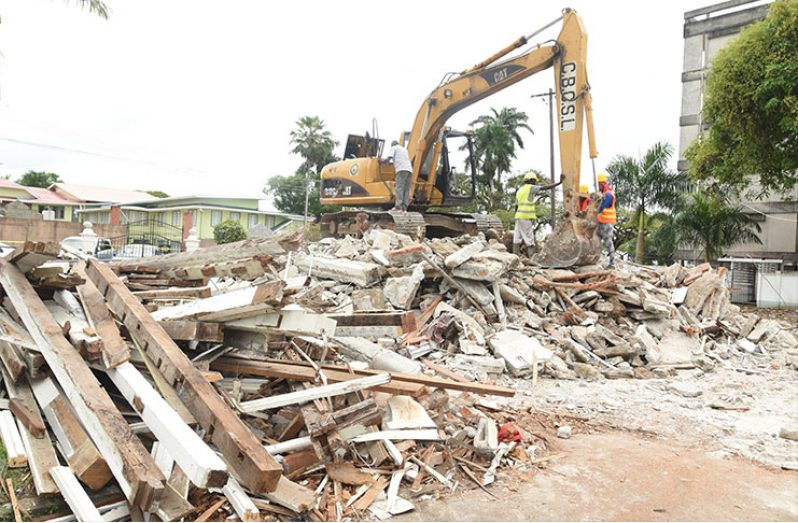 Workers demolishing the Ramphal House. [Adrian Narine photo]