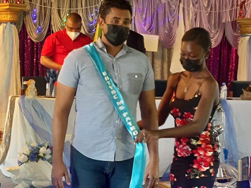 Minister Charles Ramson is inducted as Patron by Youth Ambassador Denica Henry.