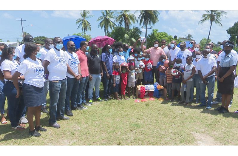 Minister of Culture, Youth and Sport, Charles Ramson Jr, along with Assistant Commissioner of Police, Clifton Hicken, is joined by beneficiaries of their distribution in Agricola. Also in photo are members of the visiting party.