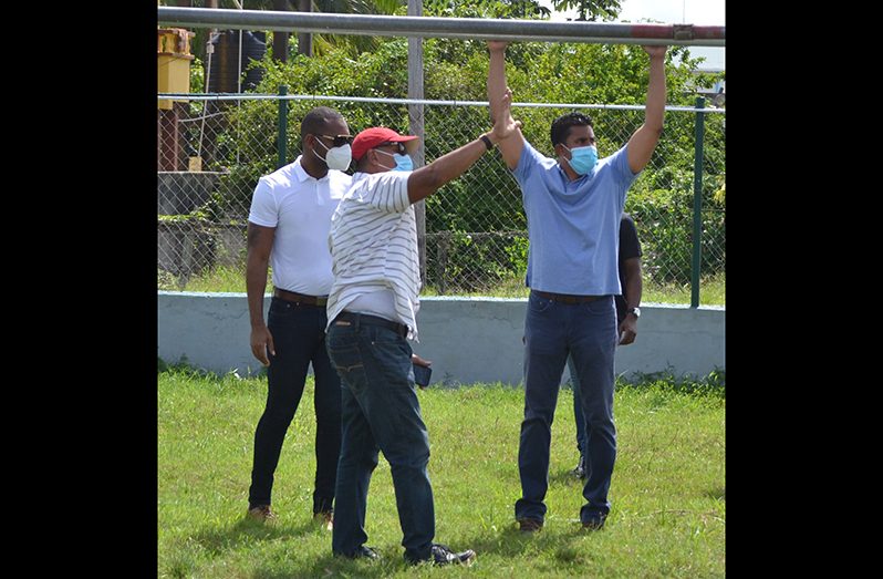 Minister of Culture, Youth and Sport, Charles Ramson Jr, checks the crossbar of a goal on the Agricola playfield during a visit yesterday, with other members of his ministry. (Photo compliments: DPI)