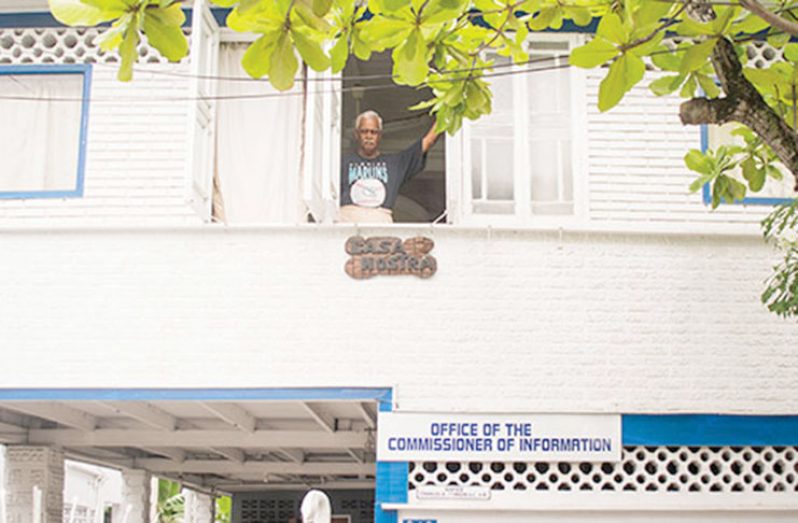 Photo taken in 2016 by Samuel Maughn, of Retired Judge, Charles Ramson Snr peering through his East Street home with the sign “Office of the Commissioner of Information”