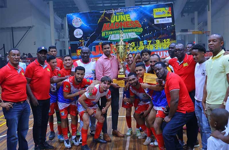 Minister of Sport Charles Ramson Jr. hands over the top prize and trophy to Road Warriors' captain in the presence of teammates and other officials.