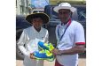 Randy Latif receives cricket shoes from coach Latchman Yadram